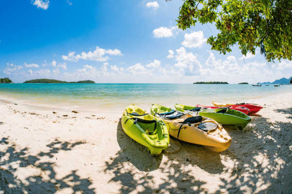 kayaks sitting on the beach awaiting kayak users at phi phi islands