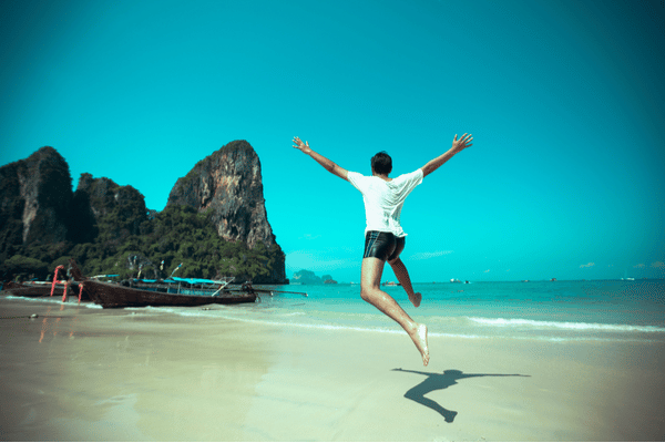 man jumping athletically along the beach in Phuket