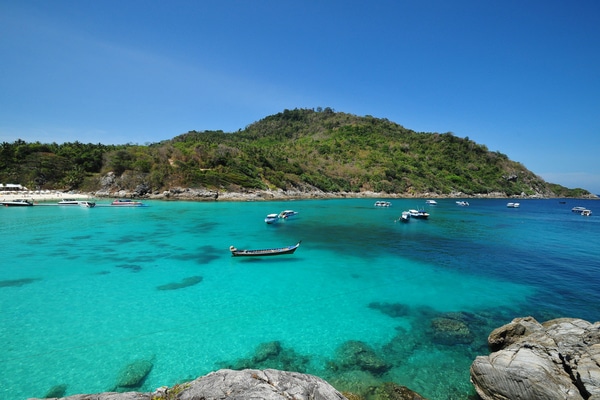 a birds eye view of raya islands as with boats anchored in the light blue waters